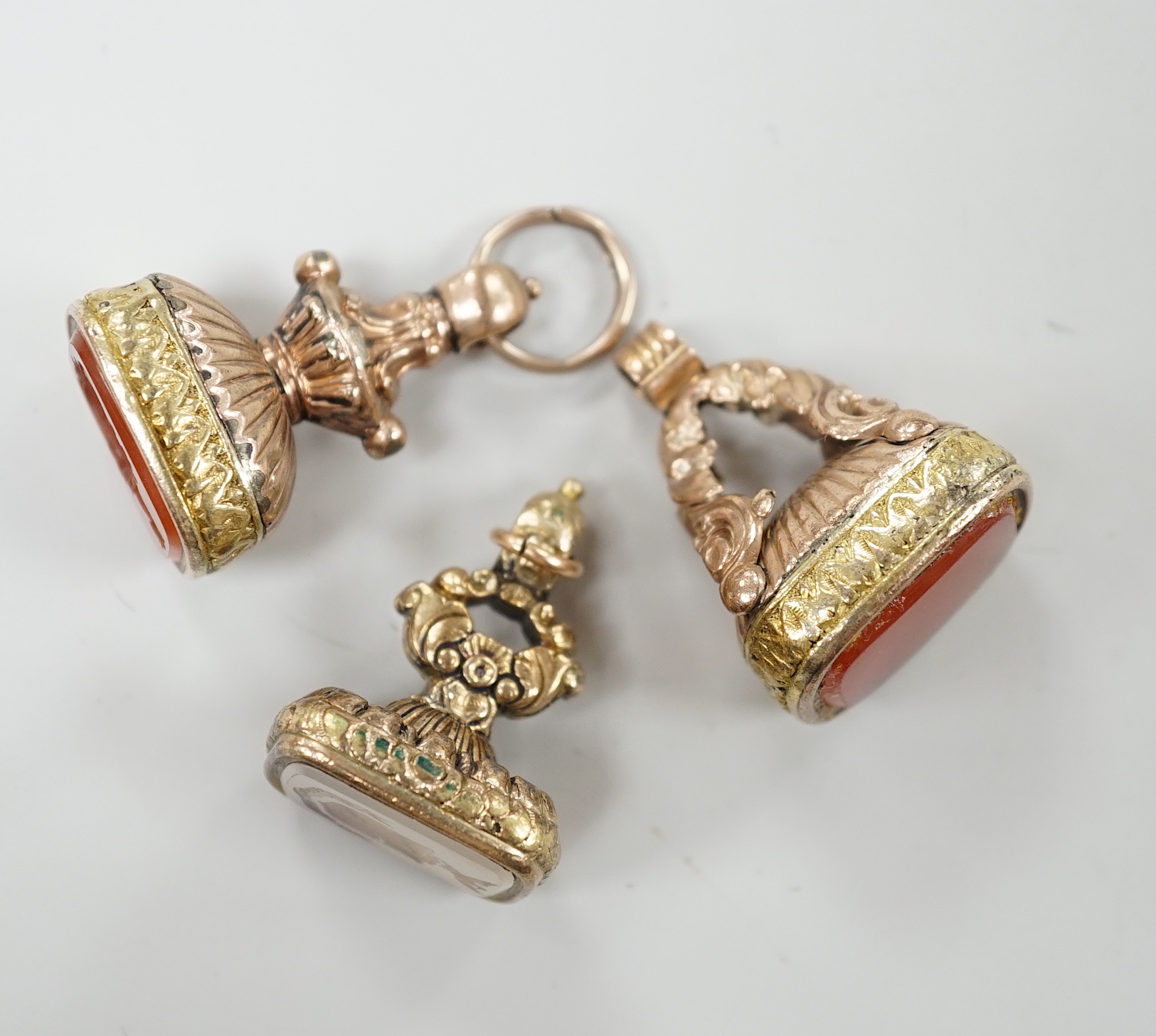 Three assorted Georgian gold plated and chalcedony set fob seals, two with carved matrix, approx. 35mm.